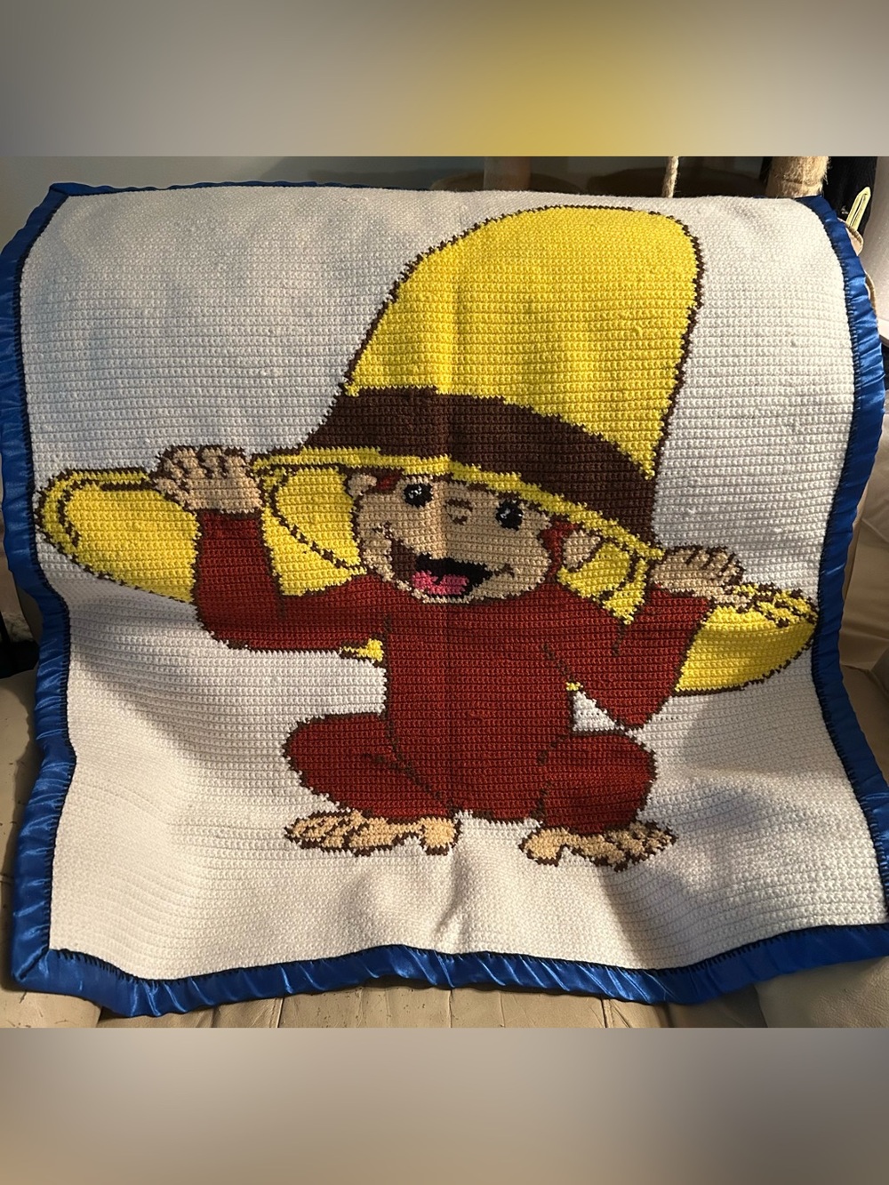 Handmade Crochet Blanket featuring Curious George Peeking Out Of A Yellow Hat.